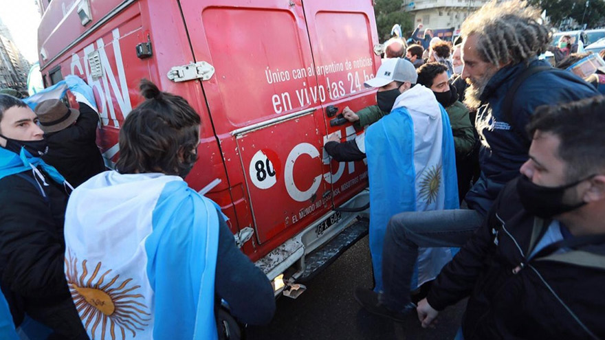 Personas subiertas con banderas cargan contra el móvil de C5N.