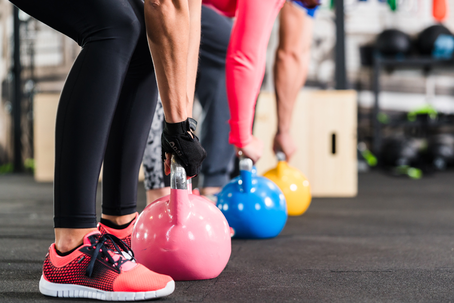 Group having functional fitness training with kettlebell in sport gym
